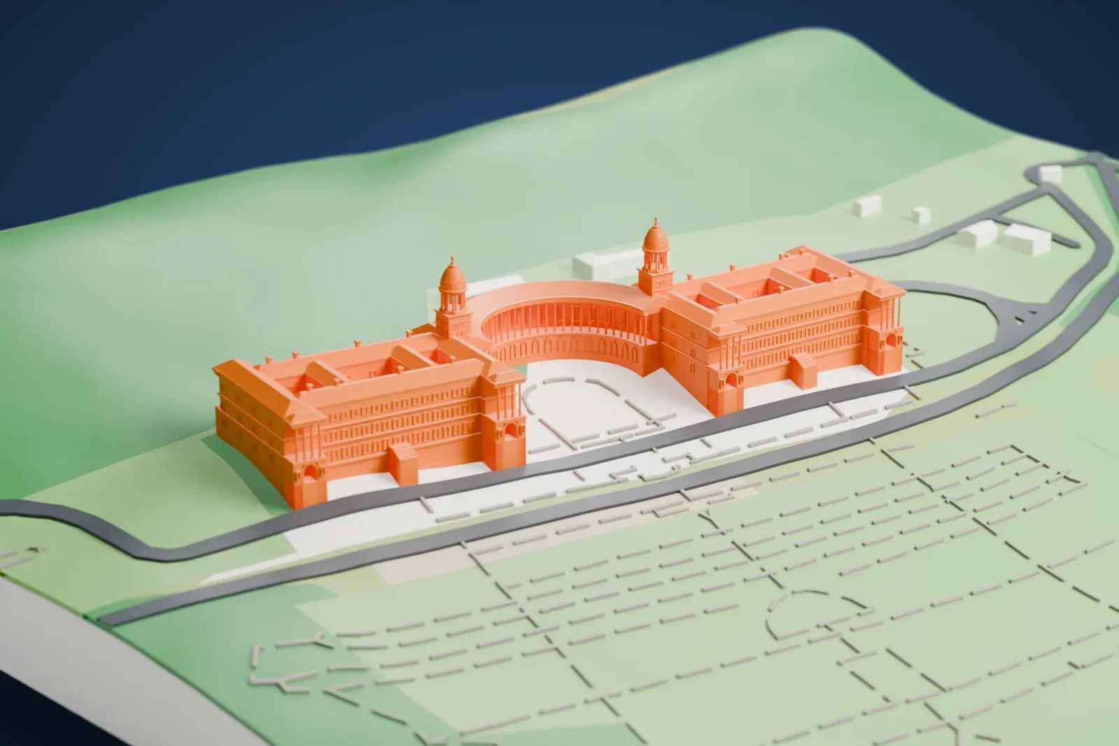 A white 3D print of the Union Buildings, two long wings joined by a curved colonnade with a domed tower at each end, set on a green hillside with roads and gardens around it.