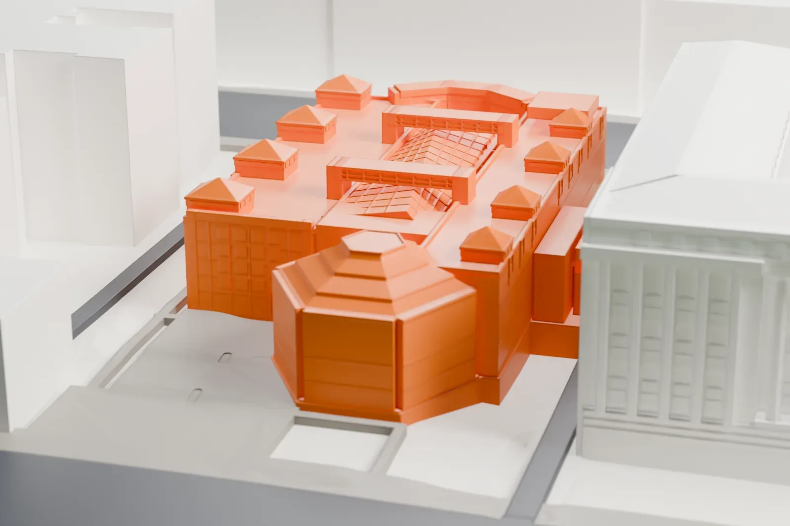 A white 3D print of the United States Holocaust Memorial Museum, a broad, low building on its city block, among the surrounding buildings.