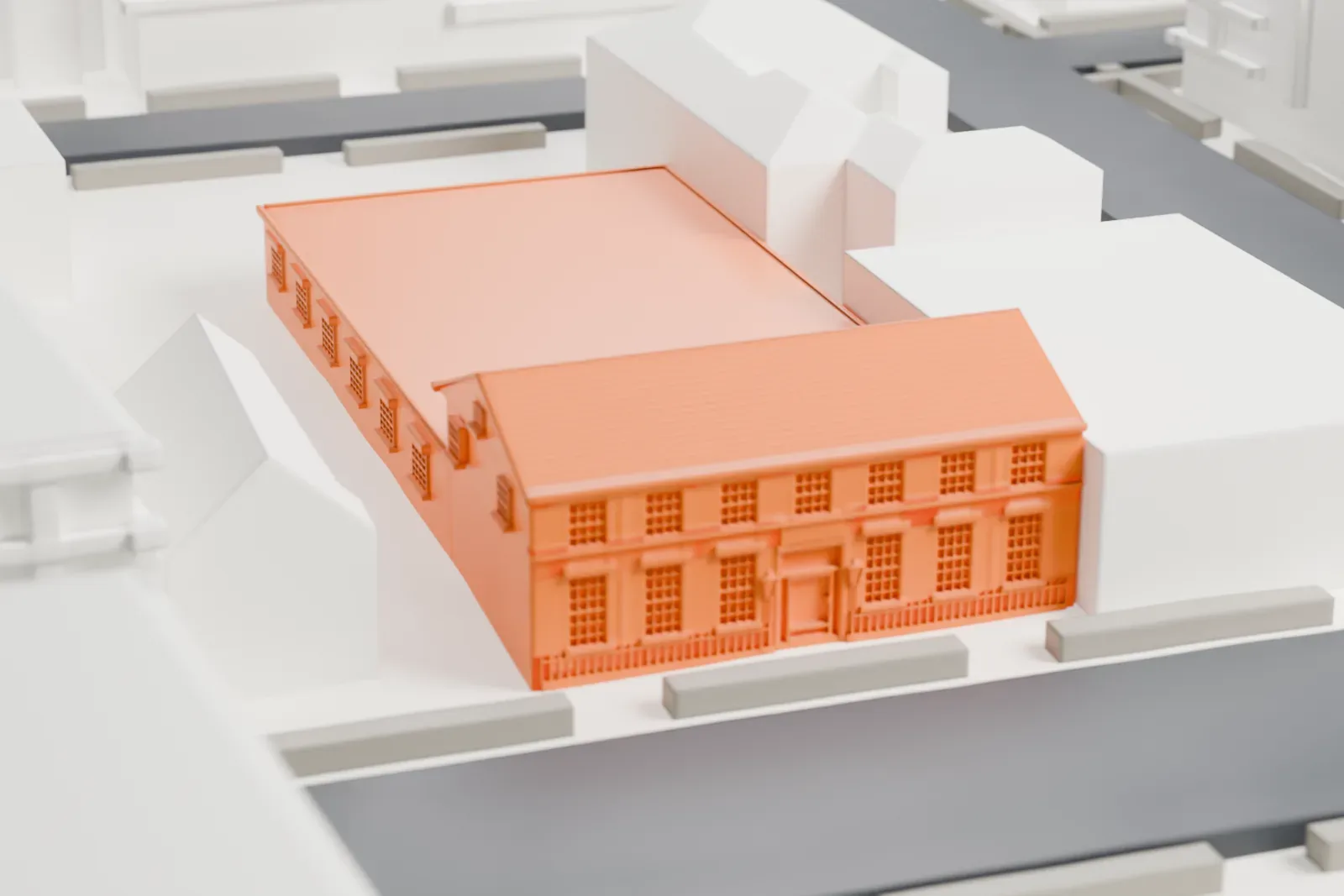 A white 3D print of the Flatbush post office, a building with a gable roof and a long low wing, among nearby buildings on a city block.