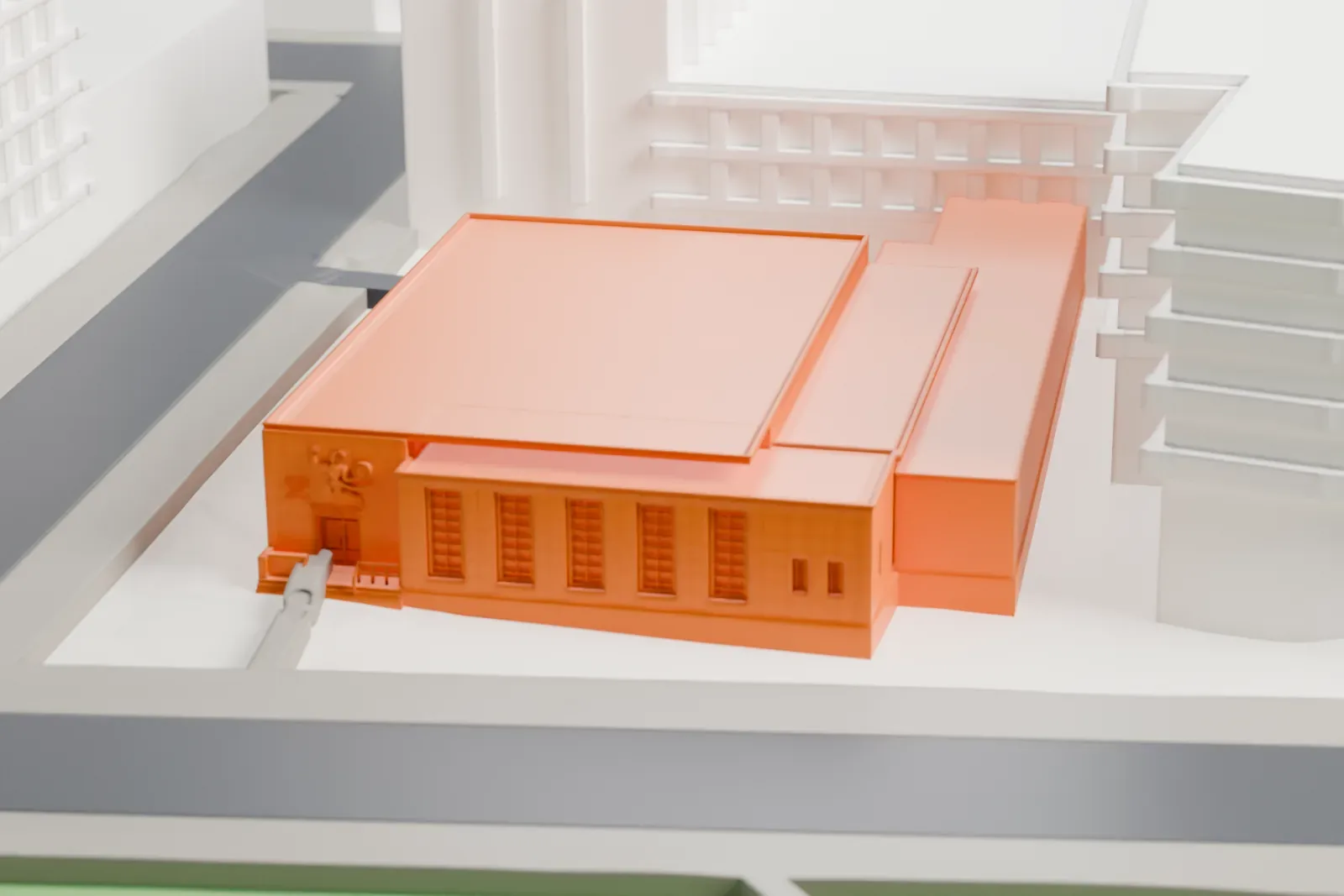 A white 3D print of the Forest Hills post office, a low flat-roofed building among taller buildings, near a small green park and wide streets.
