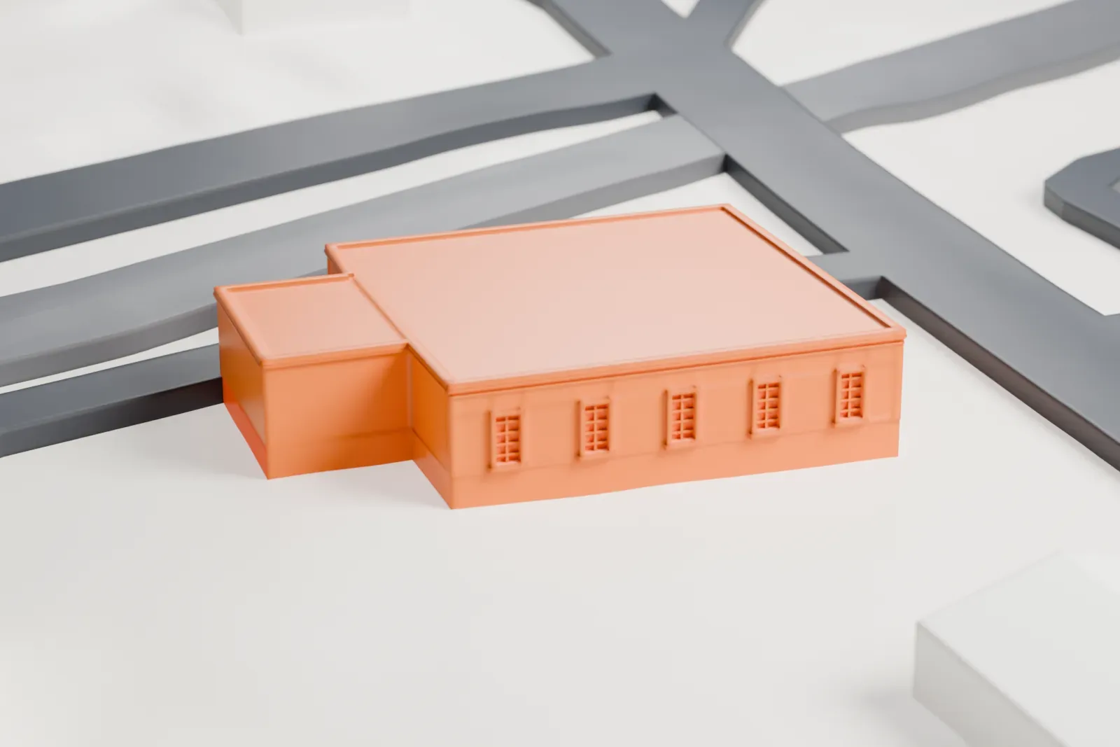 A white 3D print of the Suffern post office, a low building among streets and larger buildings, with hillside terrain beyond.
