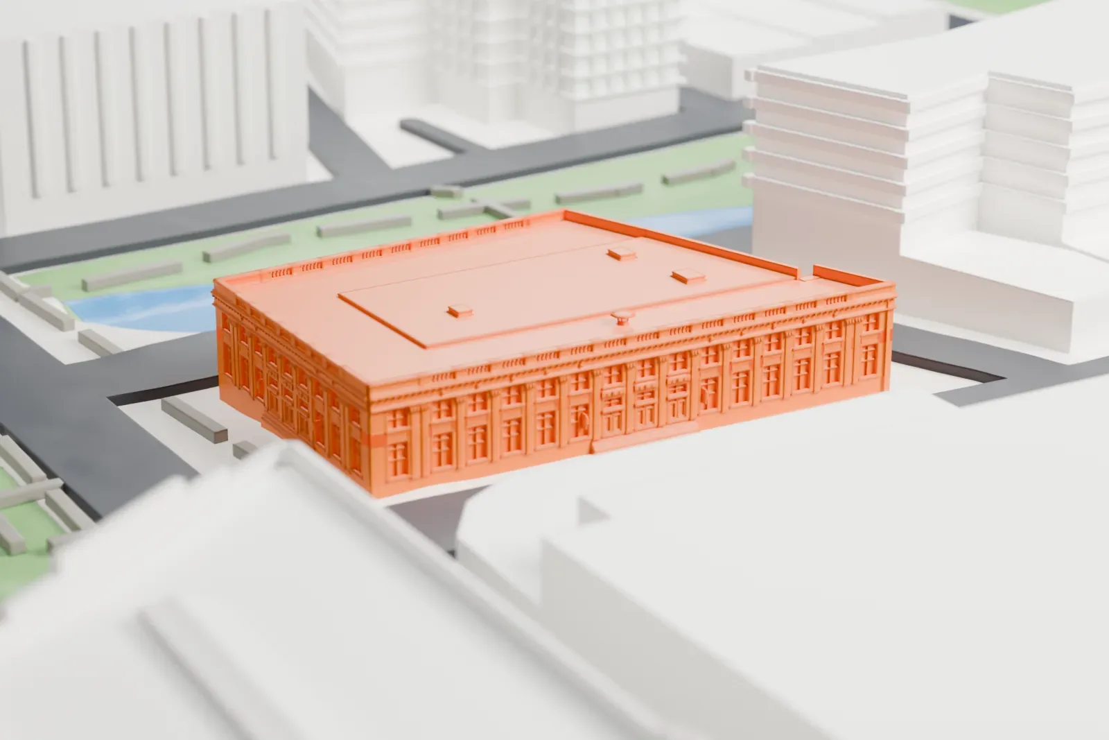 A white 3D print of the Yonkers post office, a large square building with a flat roof and a detailed street front, set among streets with a small park and water beside it.