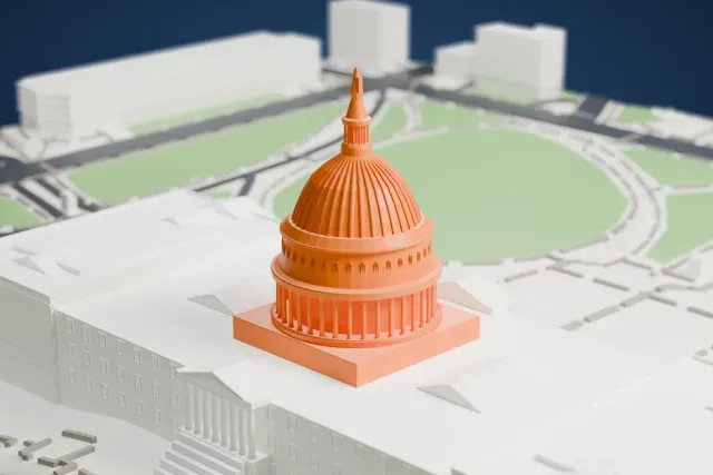 A white 3D print of the United States Capitol, a wide building with a ribbed central dome, two wings and columned porticos, set among lawns and curving paths.