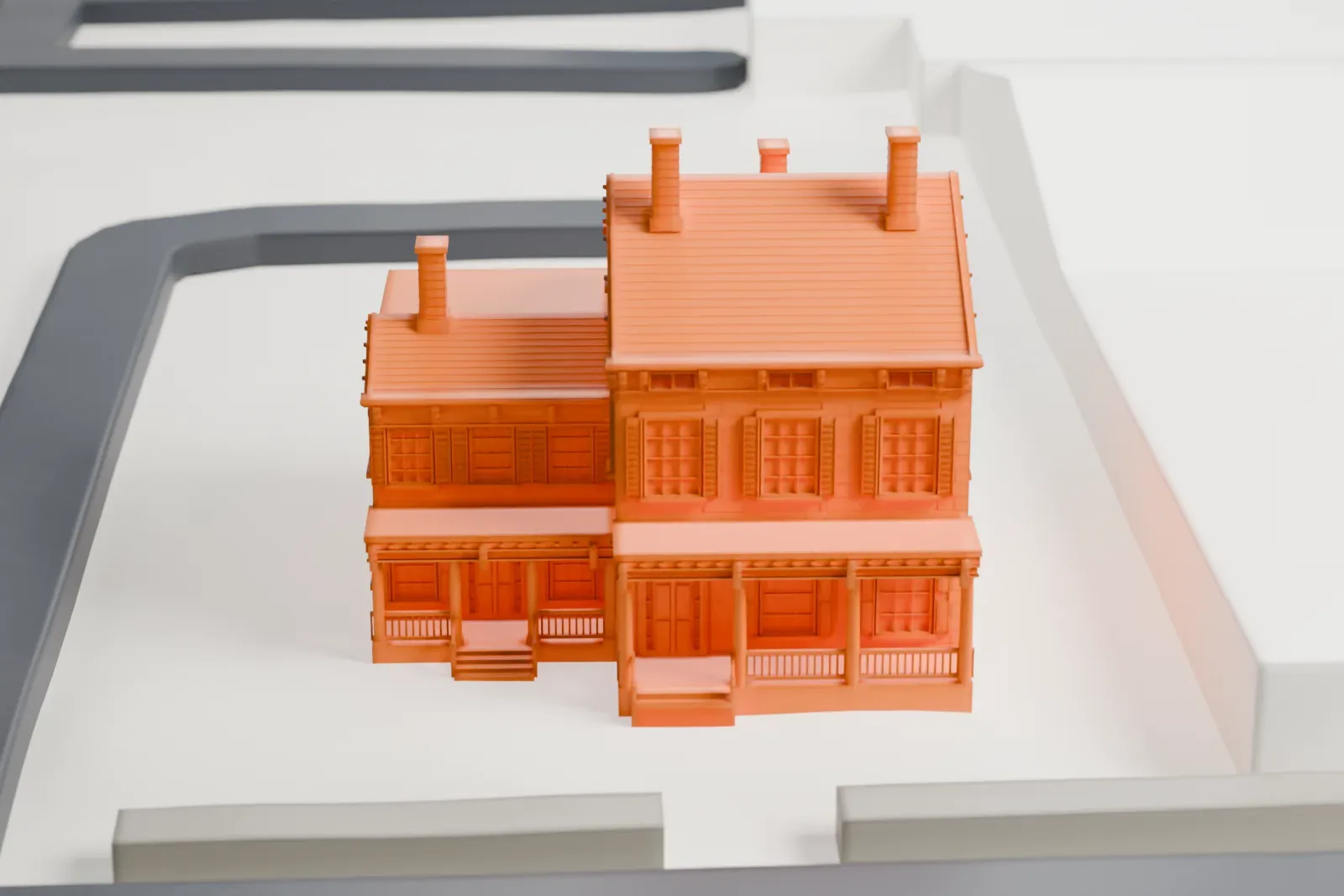 A white 3D print of the Van Wagenen House, a house with a pitched roof, several chimneys and front porches, standing at a street corner among low buildings.