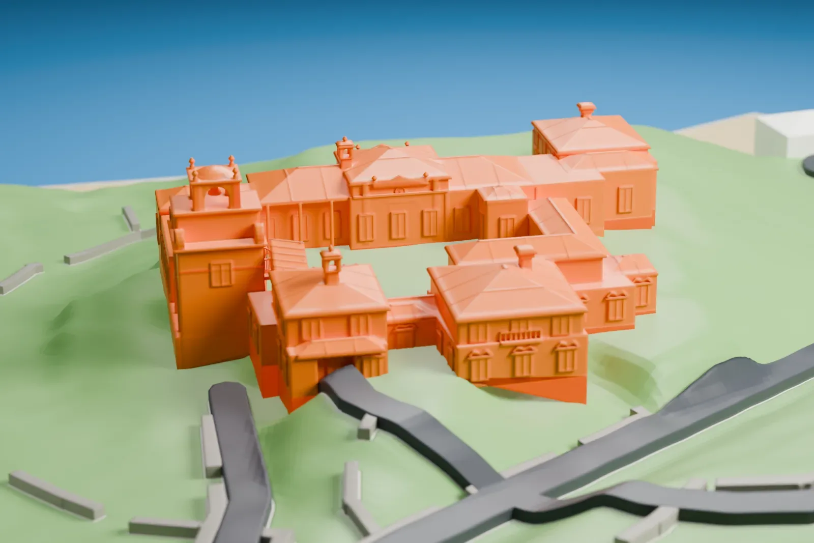 A white 3D print of the Vanderbilt Museum, a cluster of buildings around a courtyard on grassy ground, with winding roads nearby and water beyond.