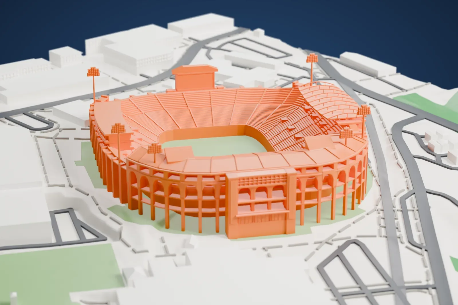 A white 3D print of Vaught–Hemingway Stadium, an oval stadium with tiered seating, an arched outer wall and tall light towers, beside large buildings, roads and green slopes.