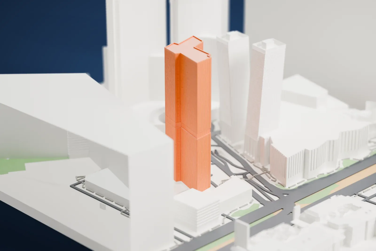 A white 3D print of Veer Towers, two tall towers leaning in opposite directions with patterned facades, standing among large curved buildings.