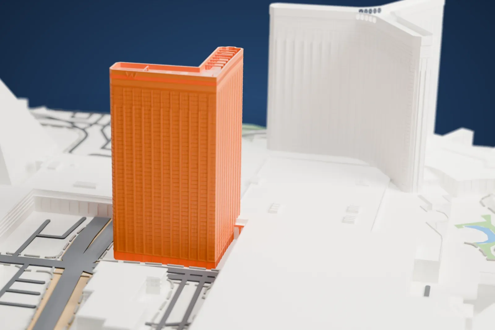 A white 3D print of W Las Vegas, a tall slab hotel tower with vertical window strips and a frame jutting out from its roof, standing beside a large neighboring building.