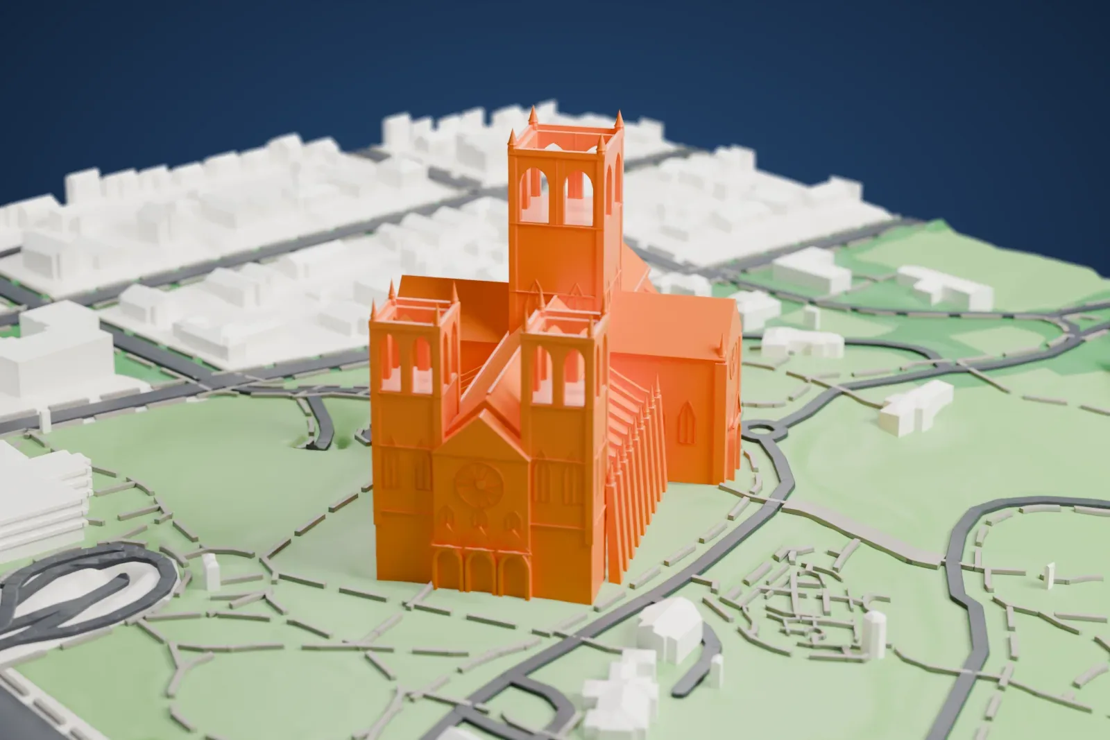 A white 3D print of Washington National Cathedral, a Gothic-style church with three towers, standing among green grounds, winding paths and low buildings.