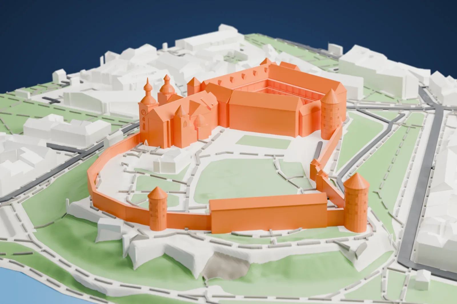 A white 3D print of Wawel Castle, a walled castle with round towers and small domes on a green hill above a river, surrounded by dense city buildings.