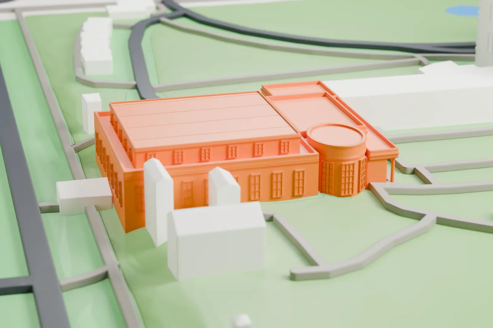 A white 3D print of the West Wing, a low office block among the other buildings of the White House site.