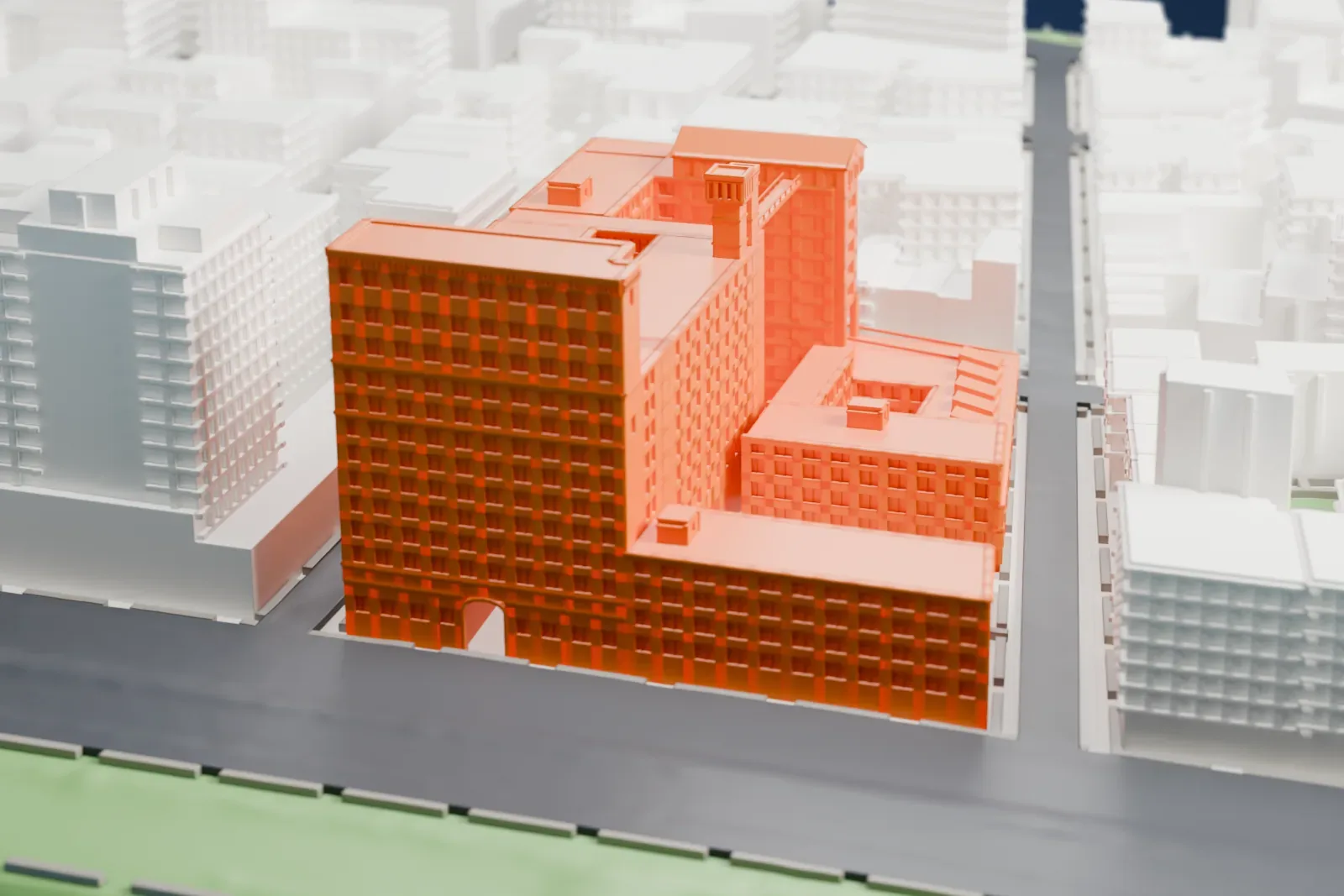 A white 3D print of the Westbeth complex, a low multi-winged block with a taller tower section, with city streets on one side and a park strip and water on the other.