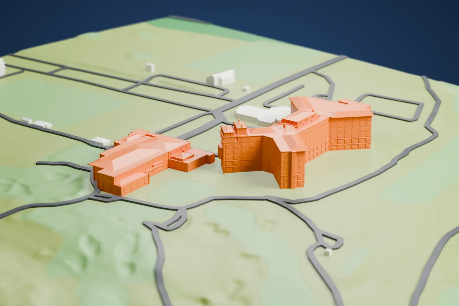 A white 3D print of the Westchester Country Club clubhouse, a group of wings set among green golf grounds with winding roads around them.