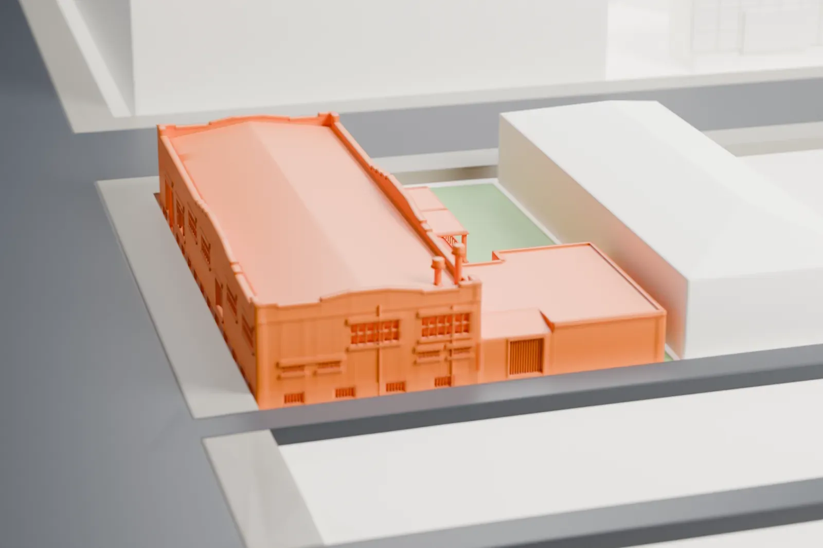 A white 3D print of the Western Wholesale Drug Co. Warehouse, a long one-story brick building with stepped parapets and rooftop stacks, among surrounding Phoenix streets and buildings.