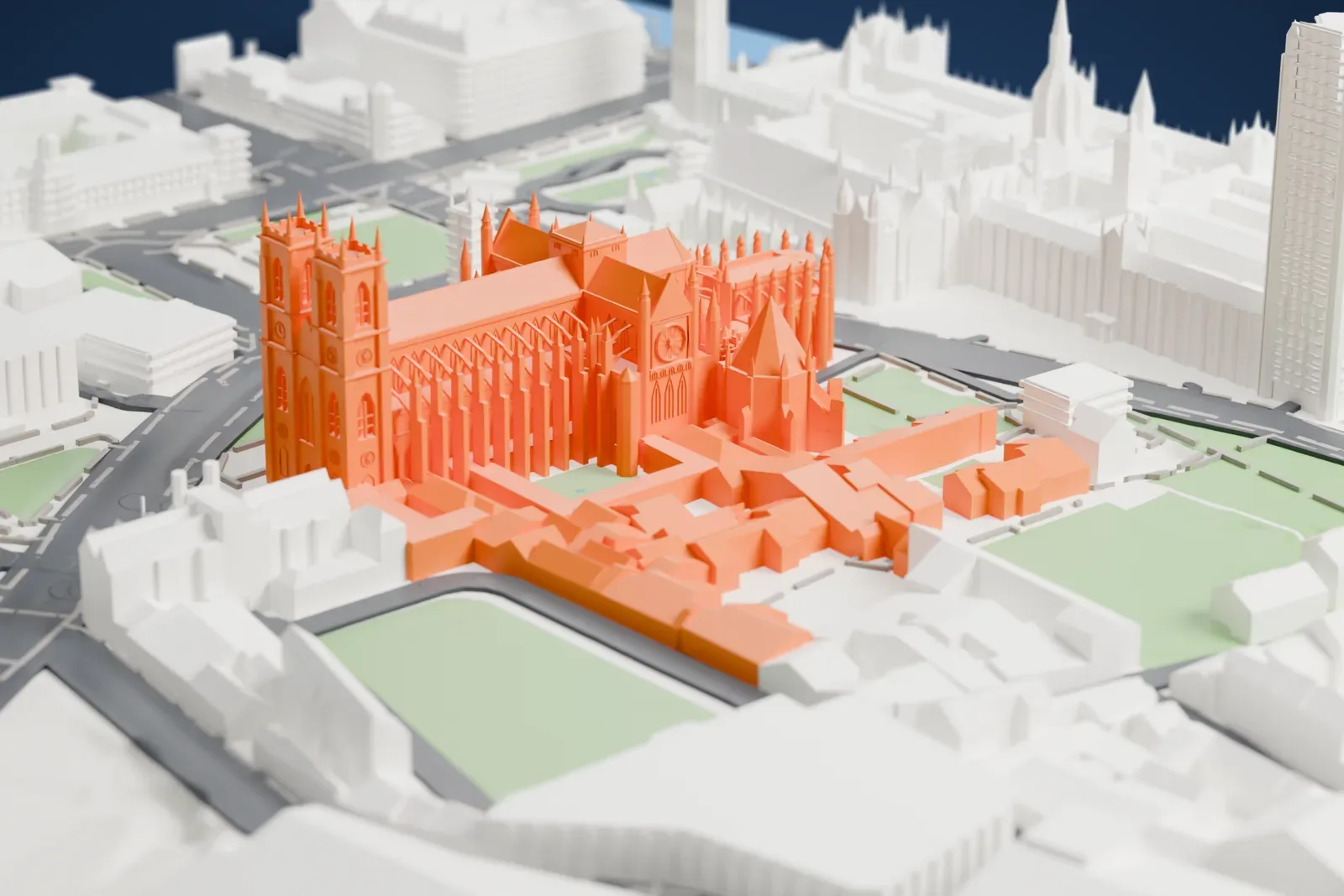 A white 3D print of Westminster Abbey, a long Gothic church with twin west towers, pinnacles and a cluster of chapels at the east end, among streets and green squares.