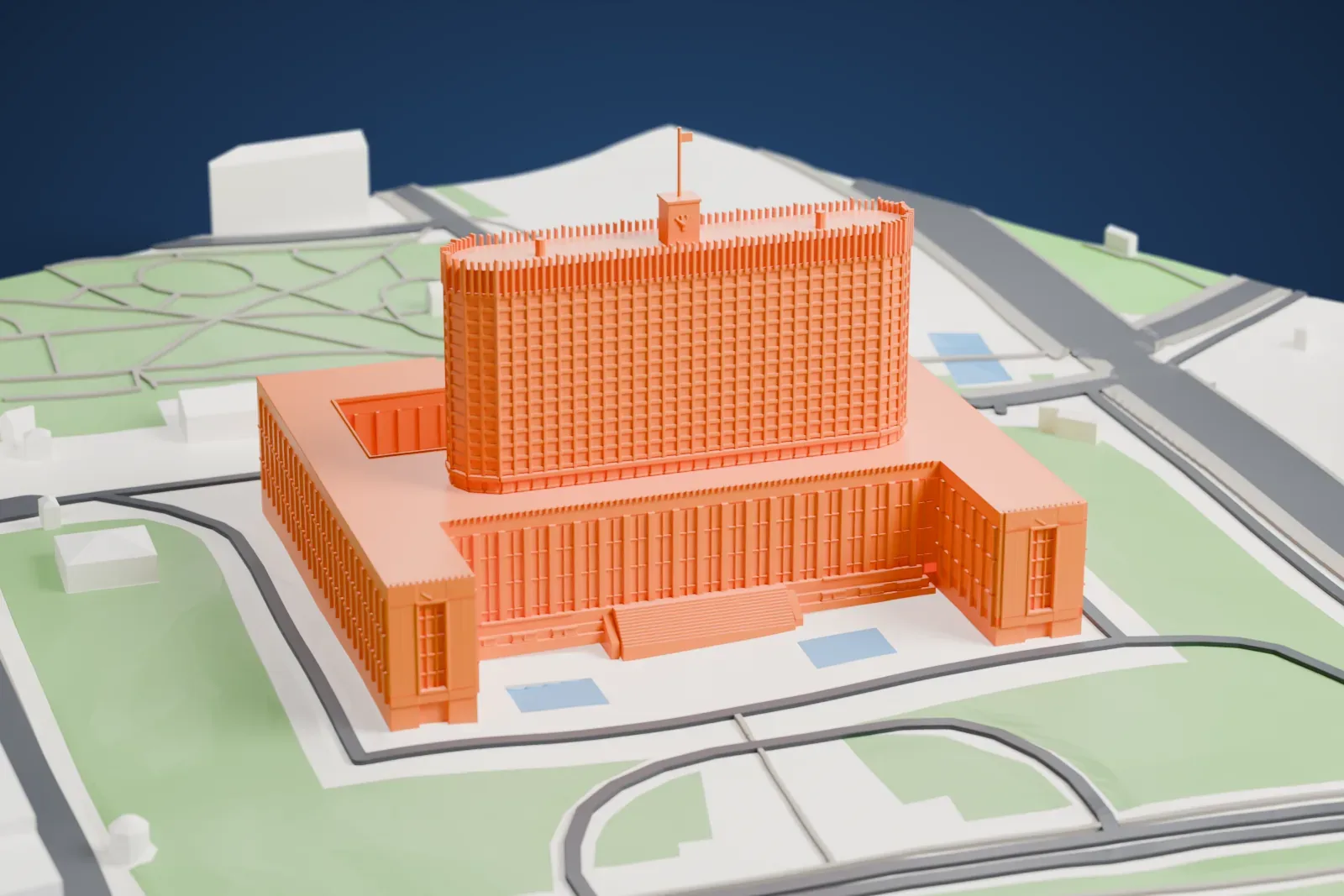 A white 3D print of the White House in Moscow, a tall government block, among the streets and buildings along its embankment.