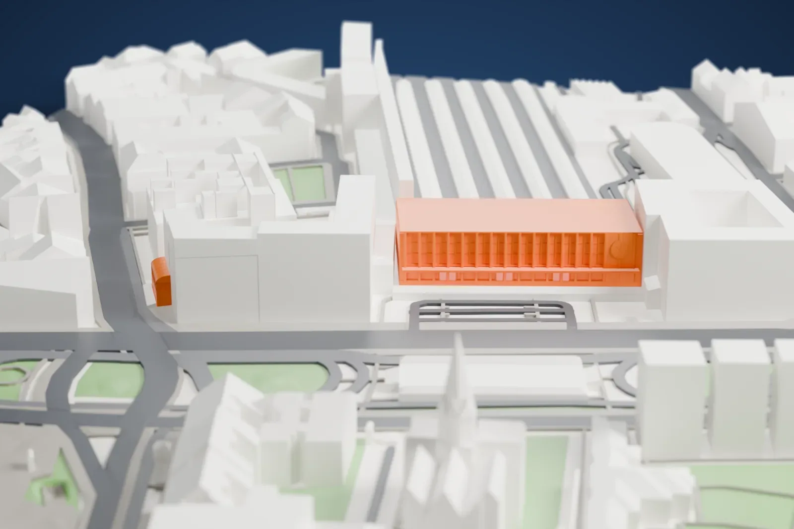 A white 3D print of Wien Westbahnhof, a long railway station with a large hall, among the surrounding city buildings.