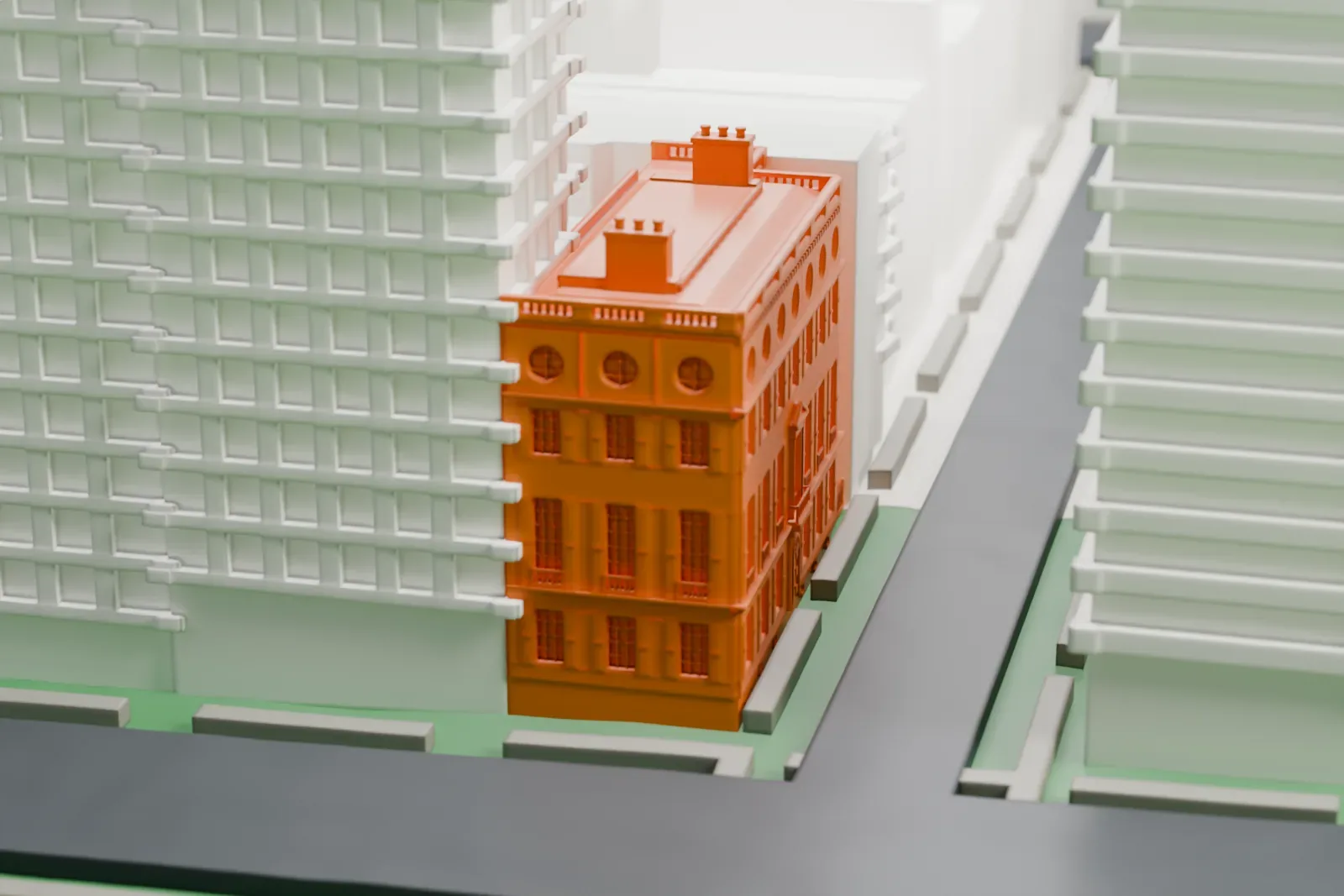 A white 3D print of the Willard D. Straight House, a mansion with a detailed facade and round windows under the cornice, between much taller buildings and a street.