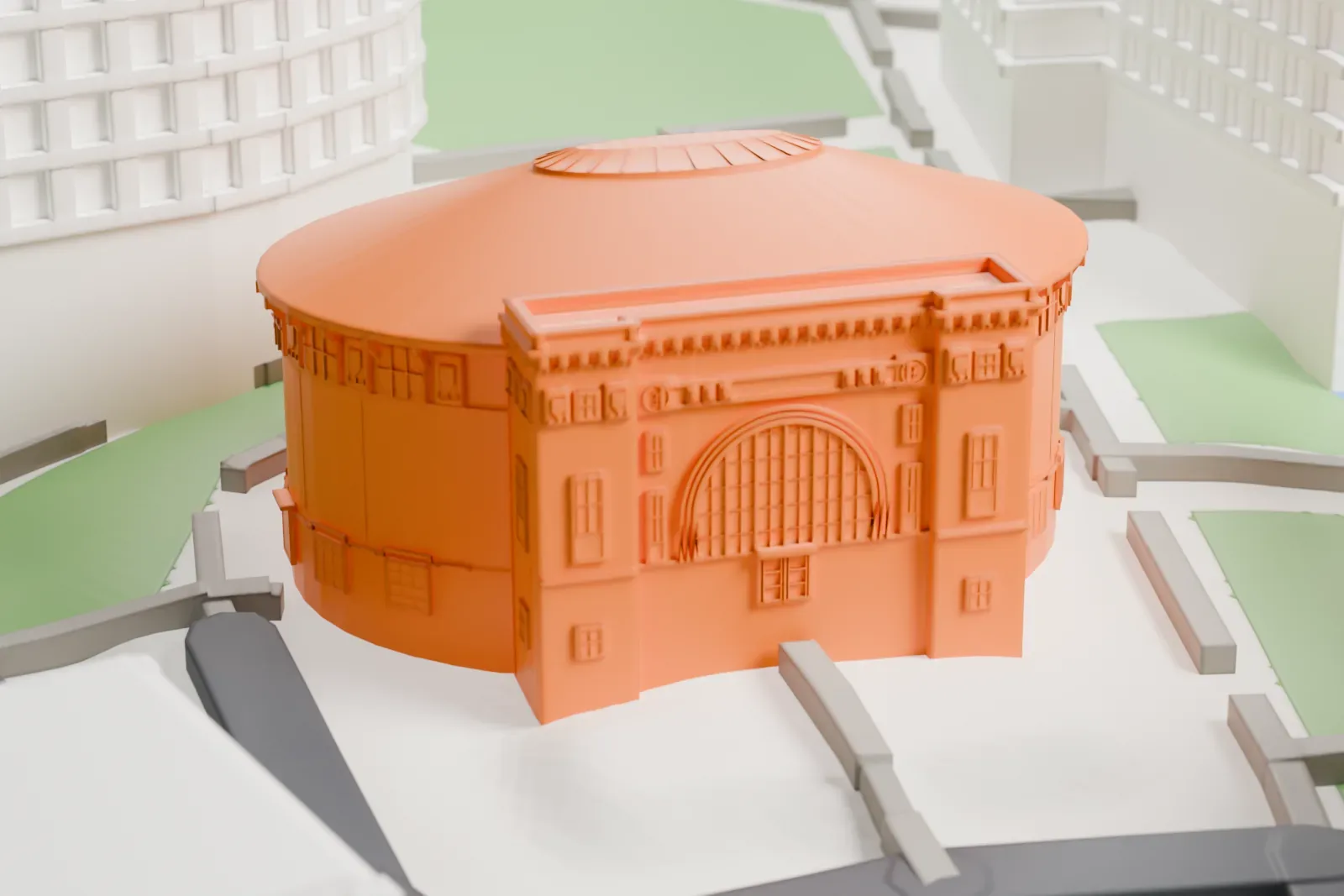 A white 3D print of the William Hall Walker Gymnasium, a round drum-shaped building with a wide ribbed roof and a tall arched front block, among larger campus buildings and green space.