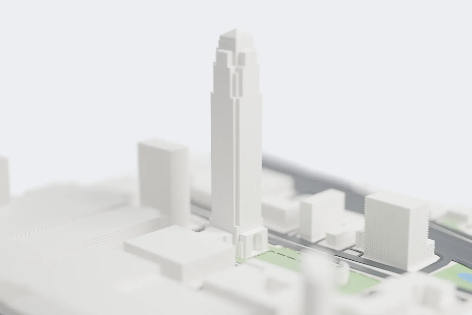 A white 3D print of Williams Tower, a very tall, narrow tower with a stepped crown and a small pyramid top, rising among lower buildings, roads and a green strip.