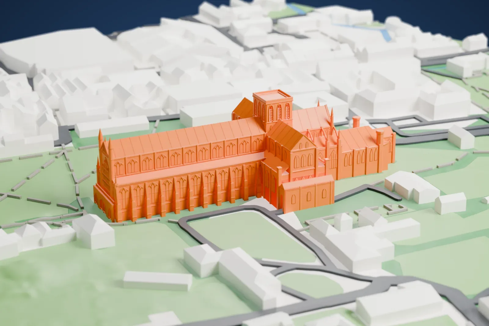 A white 3D print of Winchester Cathedral, a very long church with a low square central tower, standing on lawns crossed by paths, with buildings around it.