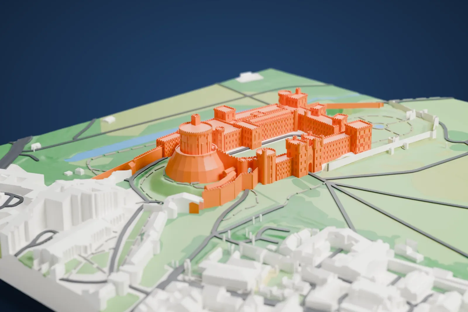 A white 3D print of Windsor Castle, with a round tower on a steep conical mound and long battlemented ranges with corner towers, set among green parkland and the buildings of the town.