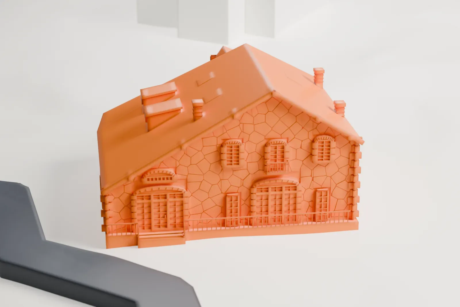 A white 3D print of the Woman's Club of Englewood, a low stone-walled building with a steep gabled roof, small dormers and chimneys, beside a curving road.