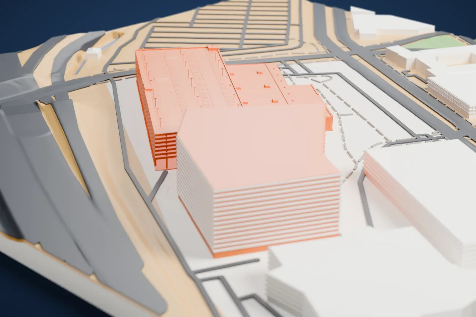 A white 3D print of the Expo and parking garage at World Market Center Las Vegas, a long multi-level building with a lower hall in front, beside wide roads and larger buildings.