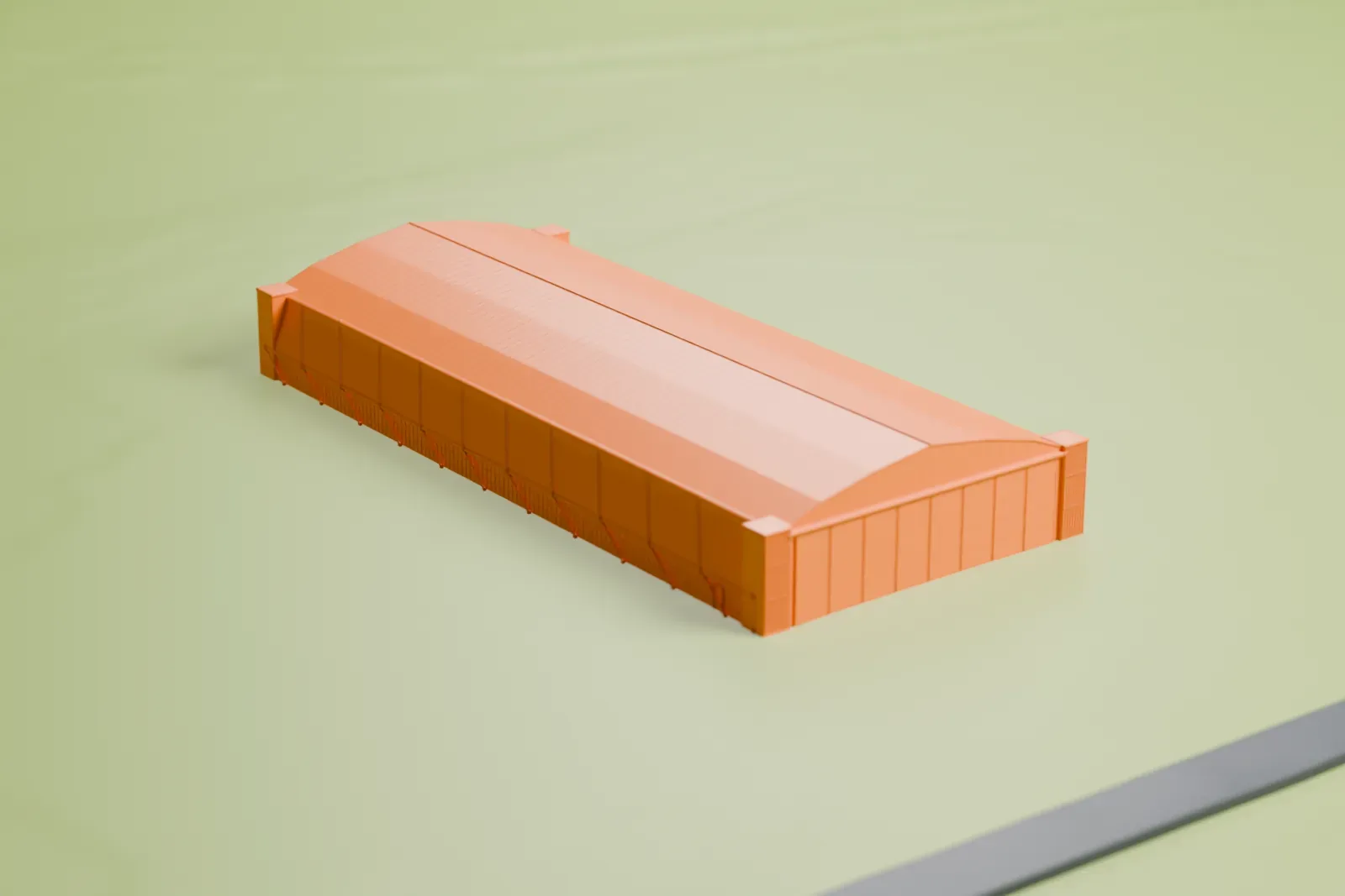 A white 3D print of the World War II Aeroplane Hangar at Tocumwal, a long, low hangar with a broad gabled roof and blocky corners, standing alone on open grassland.