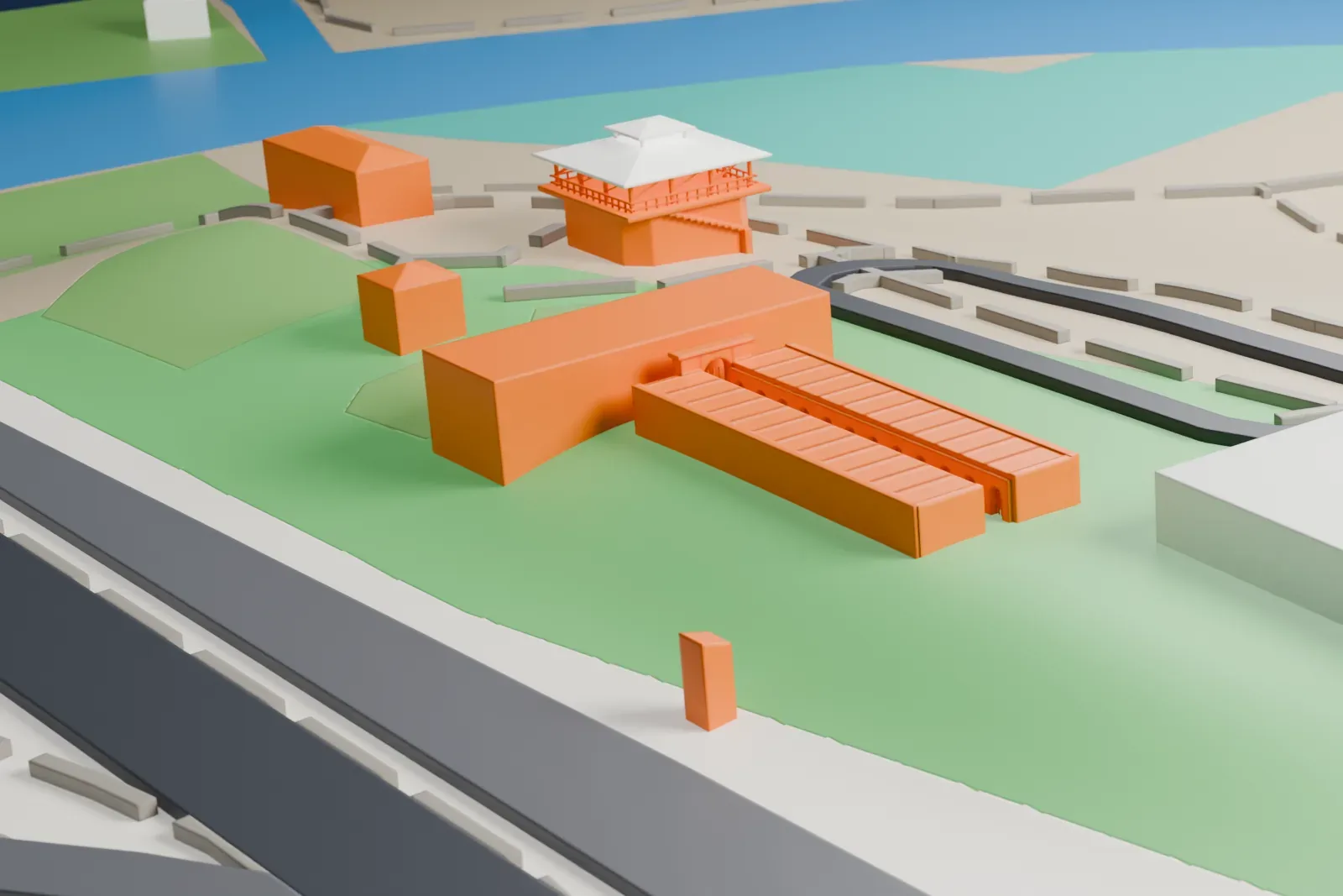 A white 3D print of the Yuma Territorial Prison, a low complex with a wide front building, two long rear wings and a small raised building with a hipped roof, on green ground beside roads.