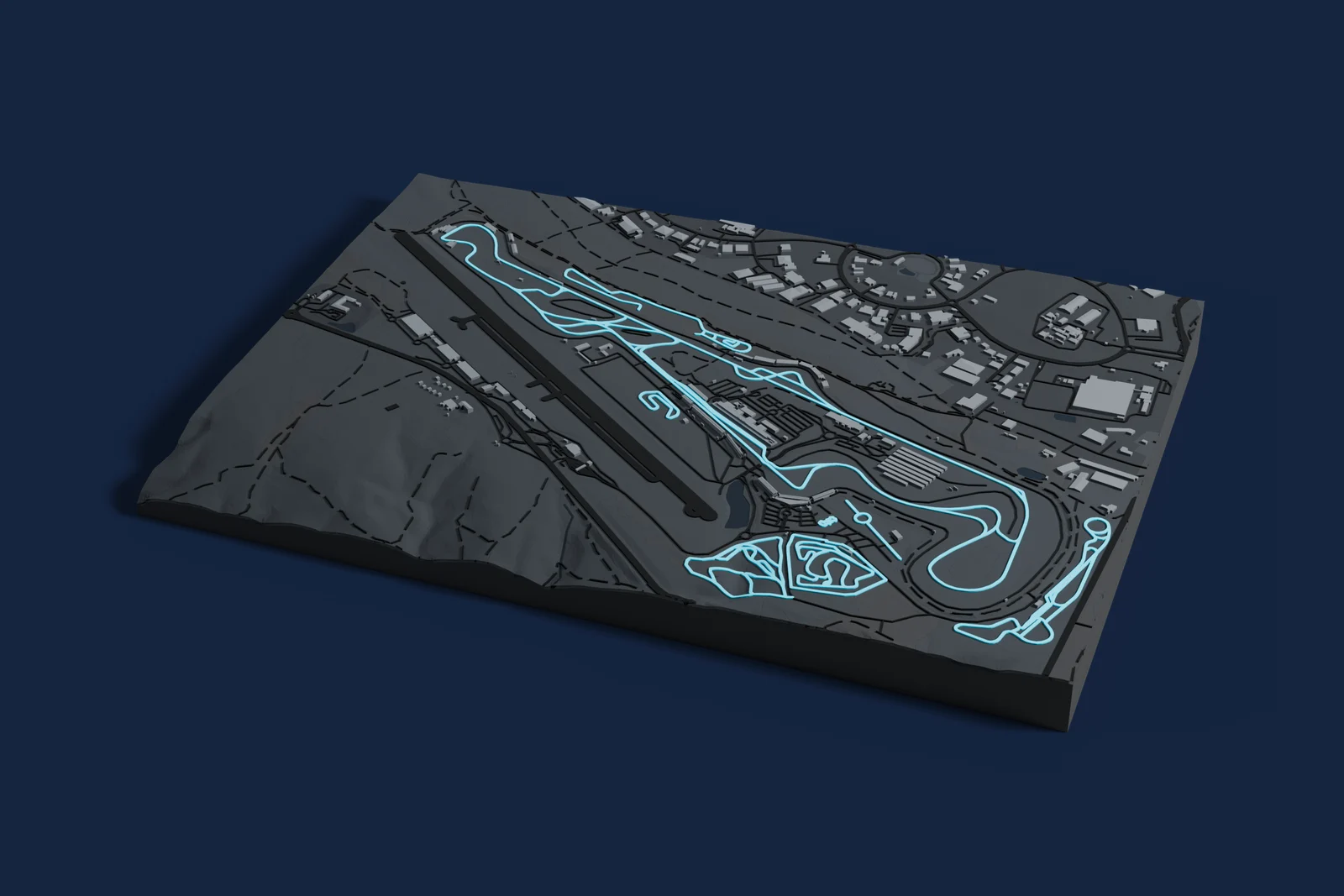 Render of a 3D printed map of Circuit Paul Ricard, the track in cyan on a dark grey model of the land and buildings around it.